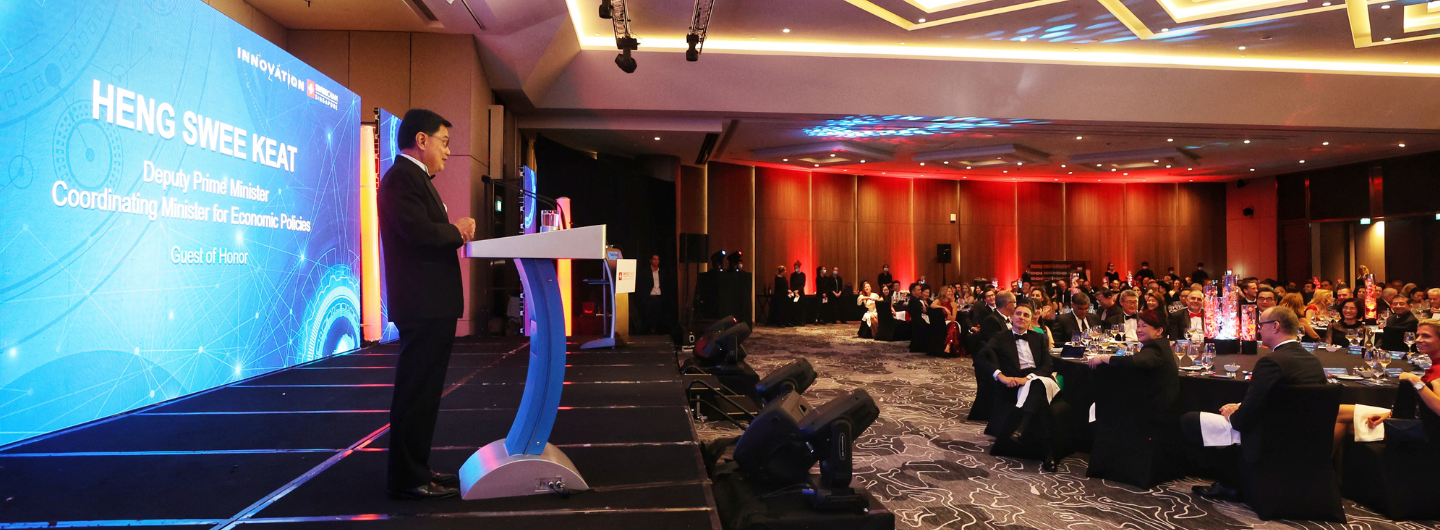 Heng Swee Keat giving a speech from a podium, with a large audience in evening wear.
